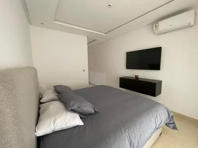 a bedroom with a bed and a flat screen tv at Bel appartement in Casablanca