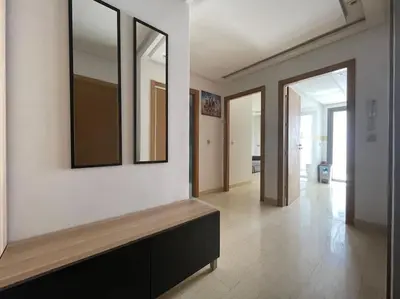 a living room with a wall with two mirrors at Bel appartement in Casablanca