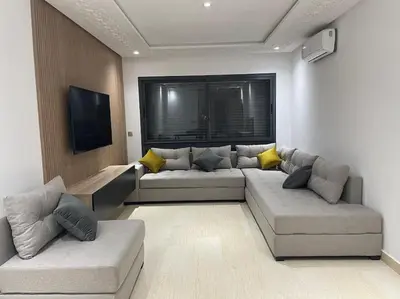 a living room with two couches and a flat screen tv at Bel appartement in Casablanca