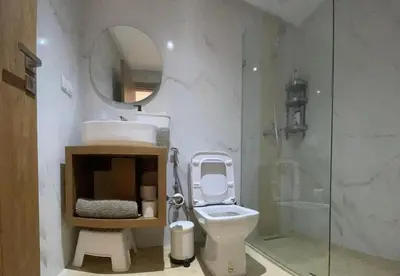 a bathroom with a toilet and a sink and a mirror at Bel appartement in Casablanca