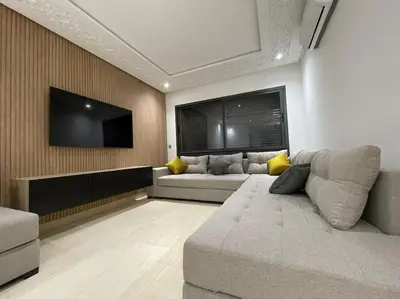a living room with a couch and a flat screen tv at Bel appartement in Casablanca
