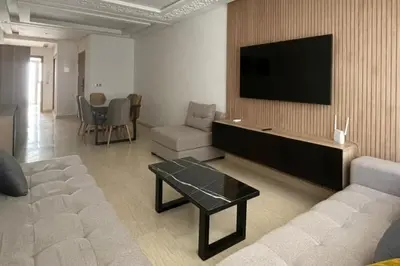 a living room with a couch and a flat screen tv at Bel appartement in Casablanca