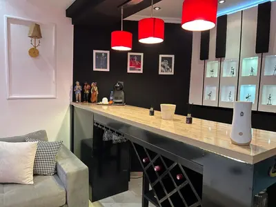 a bar with red lights and a counter with wine bottles at Ricks appartement in Casablanca