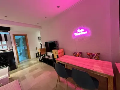 a dining room with a table and a neon sign on the wall at Ricks appartement in Casablanca