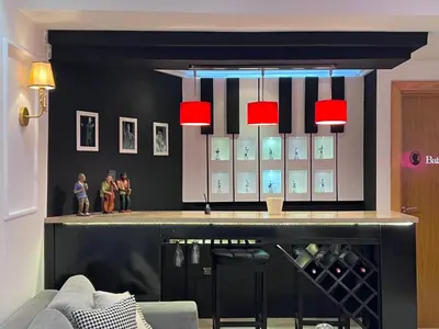 a bar with red lights and a shelf with wine bottles at Ricks appartement in Casablanca