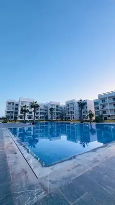 a large swimming pool in front of a building at Cosy Suite Appart in Kasba Bou Hamira