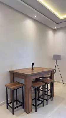 a wooden table with chairs and a lamp in a room at Cosy Suite Appart in Kasba Bou Hamira