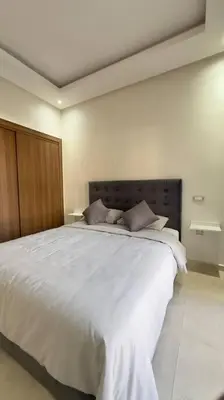 a bedroom with a large bed with white sheets at Cosy Suite Appart in Kasba Bou Hamira