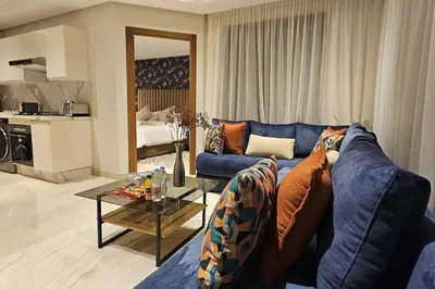 a living room with a blue couch and a table at Emplacement Central & So Stylish Près du Consulat Américain 2 minutes de Twin Center Gauthier Casablanca in Casablanca