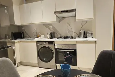 a kitchen with a stove and a washing machine at Emplacement Central & So Stylish Près du Consulat Américain 2 minutes de Twin Center Gauthier Casablanca in Casablanca