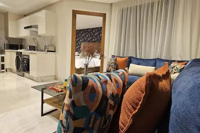 a living room with a blue couch and a table at Emplacement Central & So Stylish Près du Consulat Américain 2 minutes de Twin Center Gauthier Casablanca in Casablanca