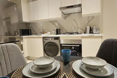 a kitchen with a table with plates and bowls on it at Emplacement Central & So Stylish Près du Consulat Américain 2 minutes de Twin Center Gauthier Casablanca in Casablanca