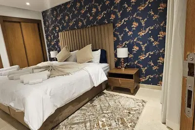a bedroom with a large bed with a blue wall at Emplacement Central & So Stylish Près du Consulat Américain 2 minutes de Twin Center Gauthier Casablanca in Casablanca