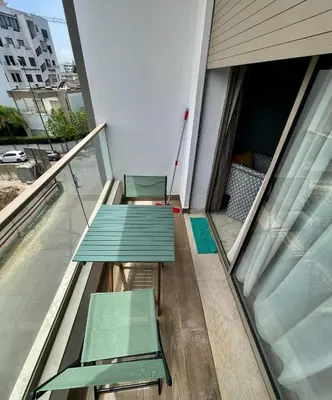 a balcony with two green benches on a building at Appartement cosy in Casablanca