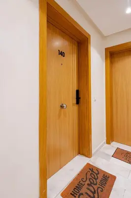 a wooden door in a room with a sign on it at AS140 élégant coeur de Casablanca avec Wifi Parking et Tramway in Casablanca