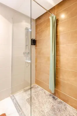 a shower with a glass door in a bathroom at AS140 élégant coeur de Casablanca avec Wifi Parking et Tramway in Casablanca