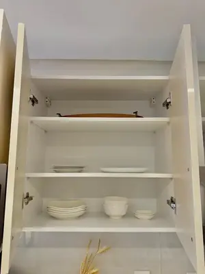 a white cabinet with bowls and plates in it at AS140 élégant coeur de Casablanca avec Wifi Parking et Tramway in Casablanca