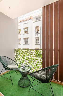 two chairs and a table in a room with a building at AS140 élégant coeur de Casablanca avec Wifi Parking et Tramway in Casablanca