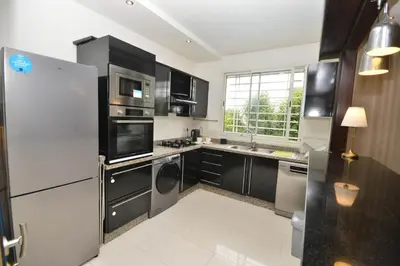 a kitchen with stainless steel appliances and black cabinets at Lovely 2 bedroom flat in Ain Diab in Casablanca