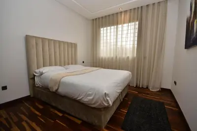 a bedroom with a large bed and a window at Lovely 2 bedroom flat in Ain Diab in Casablanca