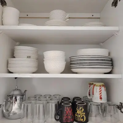 a shelf filled with plates and bowls and dishes at Élégance familiale à Skhirate près de la plage et la ville in Skhirat