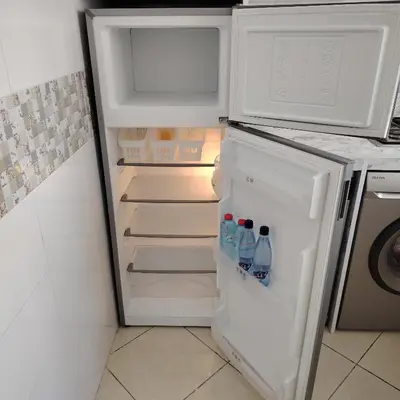 an open refrigerator with bottles of water in it at Élégance familiale à Skhirate près de la plage et la ville in Skhirat