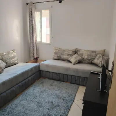 a living room with two beds and a window at Élégance familiale à Skhirate près de la plage et la ville in Skhirat