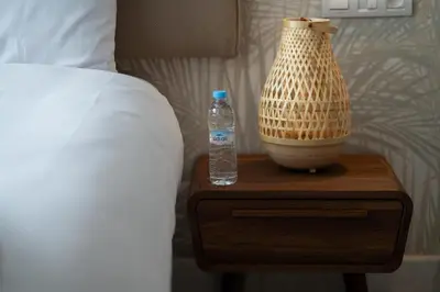 a bottle of water and a vase on a table next to a bed at Studio Raffiné en Centre Ville in Casablanca
