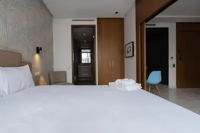 a bedroom with a large white bed and a hallway at Studio Raffiné en Centre Ville in Casablanca