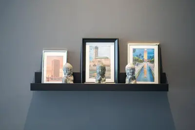 a shelf with three framed pictures on a wall at Studio Raffiné en Centre Ville in Casablanca