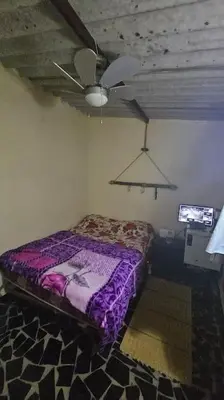 a bedroom with a purple bed and a ceiling fan at Ferme Benslimane 30 min de rabat in O Ben Slimane