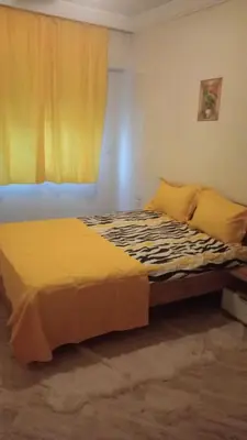 a bedroom with a bed with yellow sheets and a window at Appartement à Maarif in Casablanca