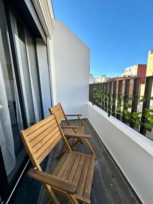 two wooden chairs sitting on the balcony of a building at Alonso studio au coeur de Maarif in Casablanca