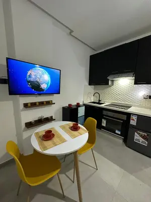 a kitchen with a white table and chairs and a tv at Alonso studio au coeur de Maarif in Casablanca