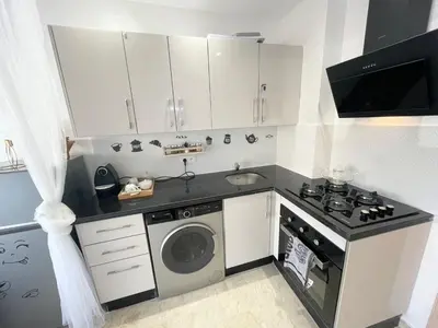 a small kitchen with a stove and a washing machine at Joli cocon en plein centre a10 min a pieds de la corniche in Casablanca