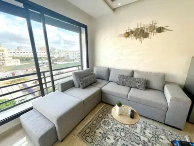 a living room with a couch and a large window at Joli cocon en plein centre a10 min a pieds de la corniche in Casablanca