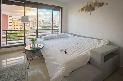 a bedroom with a bed with a view of a city at Joli cocon en plein centre a10 min a pieds de la corniche in Casablanca