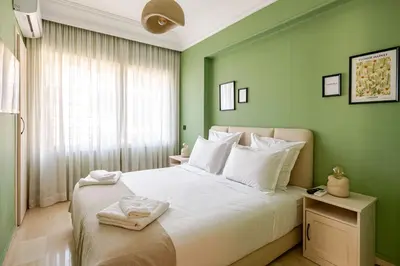 a bedroom with green walls and a bed with white pillows at The 23 Princesses by IB Signature - Stylish 2 Bedroom Apt with Wifi, Self check-in - 24 x7 Security - City View - Walk to Cafes! City Centre in Casablanca