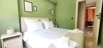 a bedroom with a large white bed with green walls at The 23 Princesses by IB Signature - Stylish 2 Bedroom Apt with Wifi, Self check-in - 24 x7 Security - City View - Walk to Cafes! City Centre in Casablanca