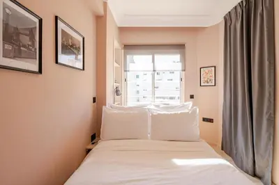 a bedroom with a bed with white pillows and a window at The 23 Princesses by IB Signature - Stylish 2 Bedroom Apt with Wifi, Self check-in - 24 x7 Security - City View - Walk to Cafes! City Centre in Casablanca
