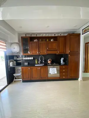 a large kitchen with wooden cabinets and a sink at Appartement Oasis Beach in Mohammedia