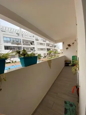 a balcony with potted plants on a building at Appartement Oasis Beach in Mohammedia