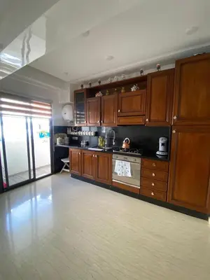 a large kitchen with wooden cabinets and a stove at Appartement Oasis Beach in Mohammedia