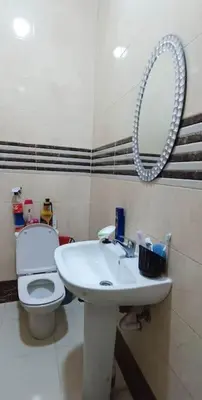 a bathroom with a toilet and a sink and a mirror at appartement calme in Casablanca