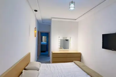 a bedroom with a bed and a tv on a wall at Havre de Confort Proche de Tout à 5 min de la Gare in Casablanca