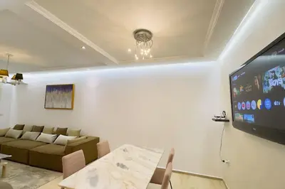 a living room with a couch and a flat screen tv at Havre de Confort Proche de Tout à 5 min de la Gare in Casablanca