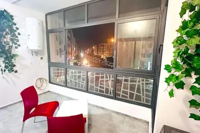 a room with a window and a red chair at Havre de Confort Proche de Tout à 5 min de la Gare in Casablanca