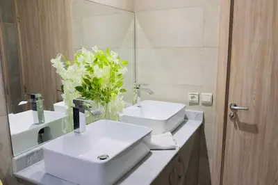 a white bathroom with two sinks and a mirror at Havre de Confort Proche de Tout à 5 min de la Gare in Casablanca