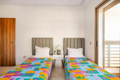 two beds sitting next to each other in a room at Appartement luxueux avec piscine dans une résidence calme in Bouznika