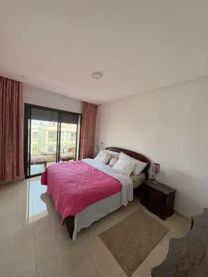 a bedroom with a large bed and a window at Appartement luxueux avec piscine dans une résidence calme in Bouznika